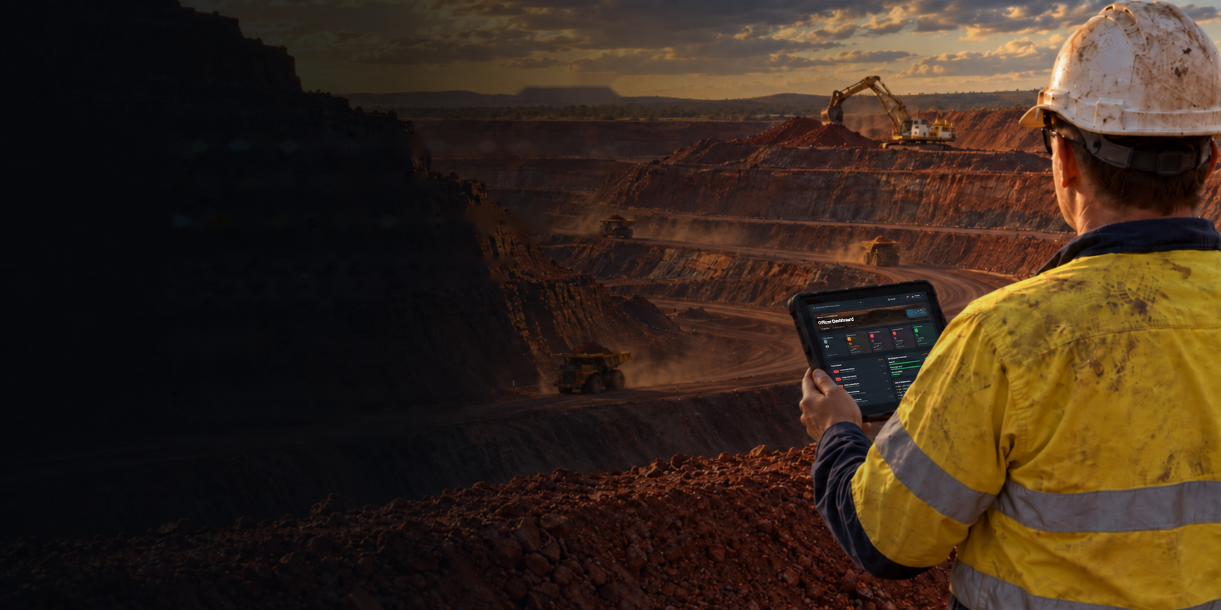 A site officer overlooking an open-cut mine, checking ARIP on a tablet